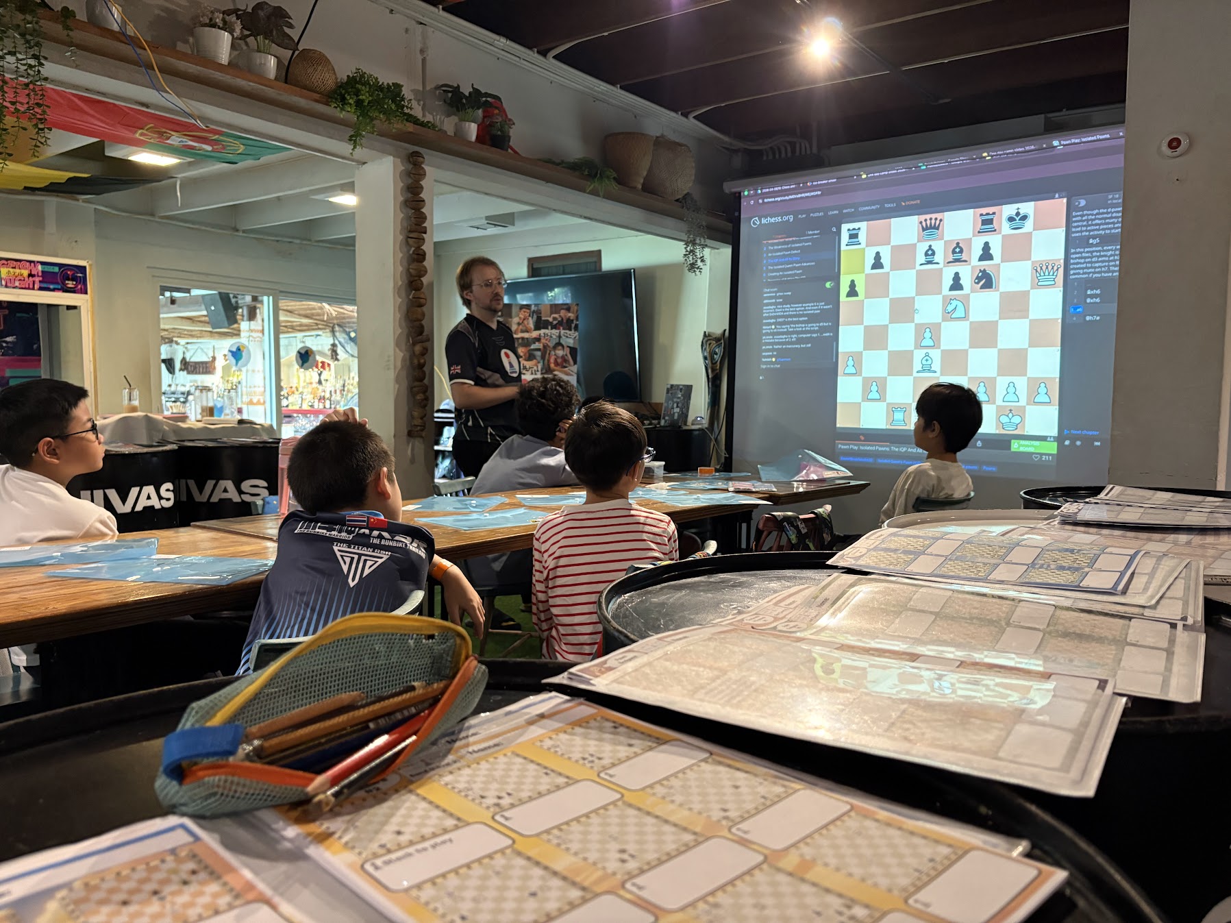 Coach teaching kids with a live Lichess lesson on the projector